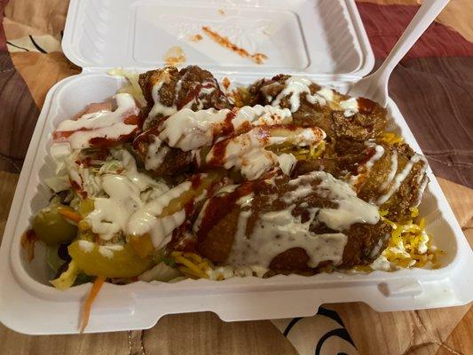 Chicken wings over rice white sauce hot sauce yum with a coke