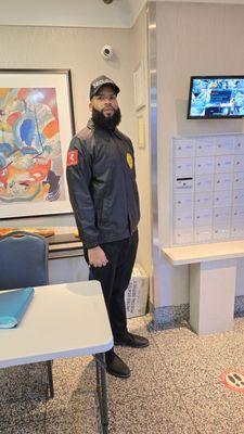 Professional security guard stationed at a residential front desk, ensuring safety and access control .