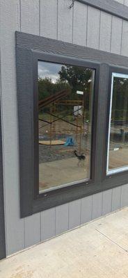 New black-frame window installation on modern gray siding, clean finish and sharp exterior detailing.