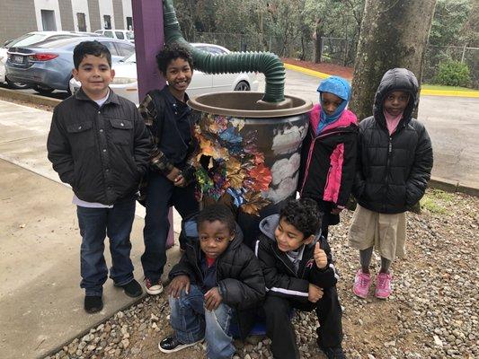 Students set up a rain barrel with their teacher.