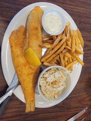 Fish dinner with fries and cole slaw.