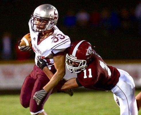 A Warriors safety tackles a Greyhounds receiver in a playoff game.