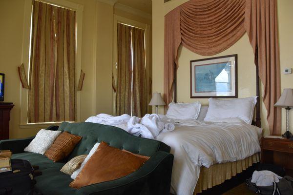 bad couch, dirty pillows and sloping bed