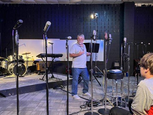 Instructor presenting microphone techniques class