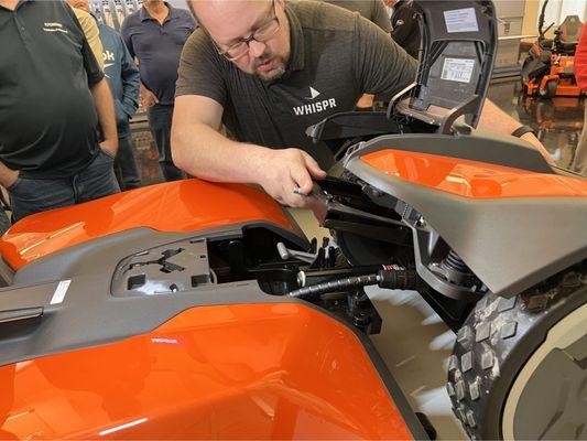A man works on a lawn mower, adjusting its components while seated on the ground in a yard.
#lawnmowerlakestevens