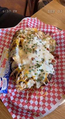 Chicken baked potato, covered with queso.