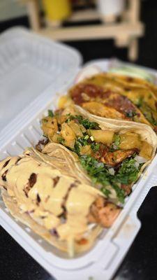 Left to right: grilled salmon trap, al pastor taco, quesobirria taco