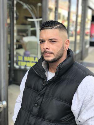 Skin fade comb over , with a shaped up beard.