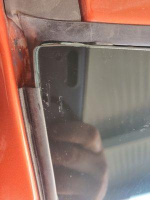Top corner of car windshield not sealed correctly or it's missing.