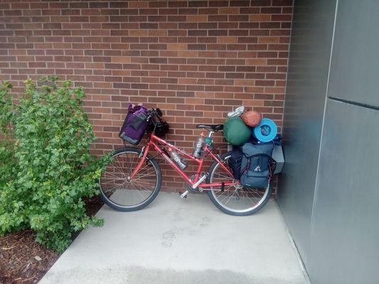 An innocent touring bike taking cover from the rain at the library. Where is the vandalization??
