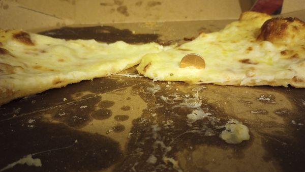 This is the pizza Domino's delivered to us last night. The penny is stuck in all the way down to the cardboard.