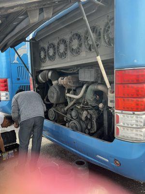 The poor bus driver trying to fix the bus.