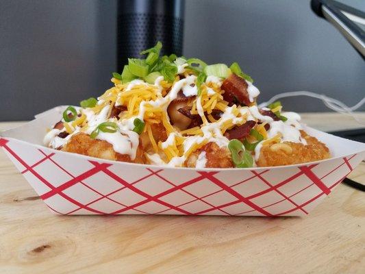 The Super Tot- tots with cheddar cheese sauce, BACON, sour cream, shredded cheddar, ranch drizzle & scallions