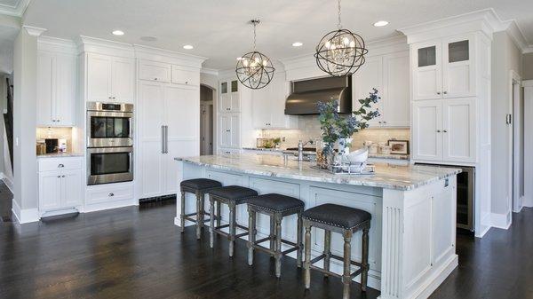 Custom white enamel cabinetry with dark hardwood floors. Kitchen by Creek Hill Custom Homes