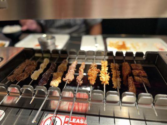 Various meats and fruits cooking