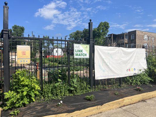 Streetside fence sign for Finding Justice Garden, a hyper local garden of fresh produce for the neighborhood.