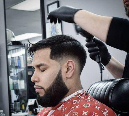 Low bald fade, combover, and beard work.