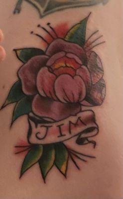 Traditional tattoo of peony with "Jim" on banner