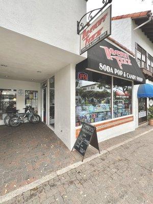 Entrance is to the left of the storefront window.