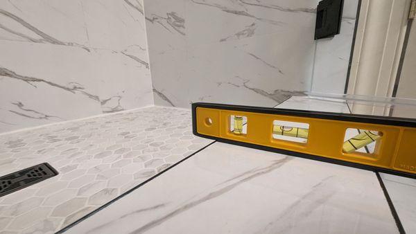 Shower ledge pitched outwards instead of towards the drain.