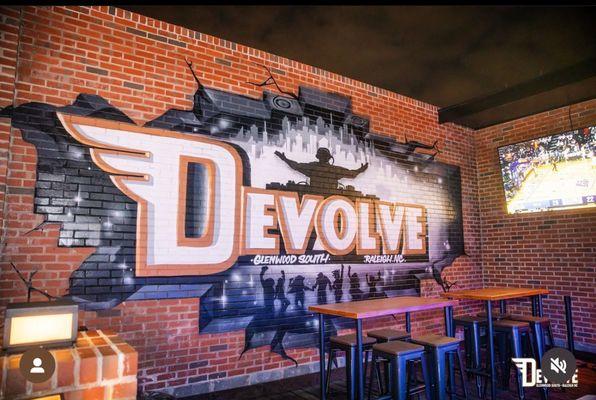 Devolve Raleigh Glenwood South Bar hand painted outdoor mural using spraypaint branding and logo installation