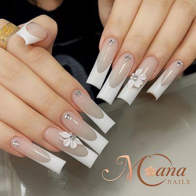 Deep French acrylic nails with milky white tips, rhinestones, and 3D flowers - done at Moana Nails (Honolulu, HI).