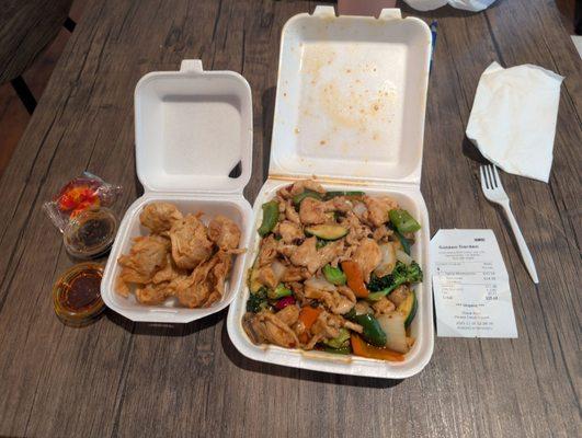 On the right is an order of Szechuan chicken, and on the left is spicy wontons with a side of spicy chili and soy sauce