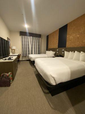 2 queen beds and has a small refrigerator and desk area.