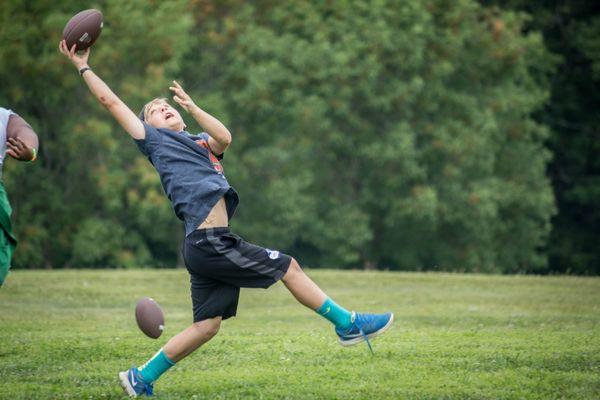 Boy playing football at camp in Franklin, Tennessee