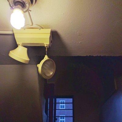 Emergency exit lighting dangling by a wire in the rear stairwell of the Marleigh.