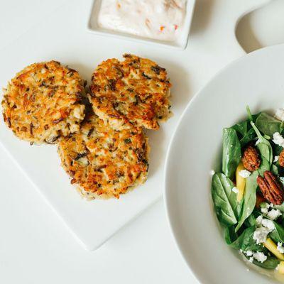 Chicken and wild rice croquettes served alongside a baby spinach, mango, goat cheese and pecan salad.