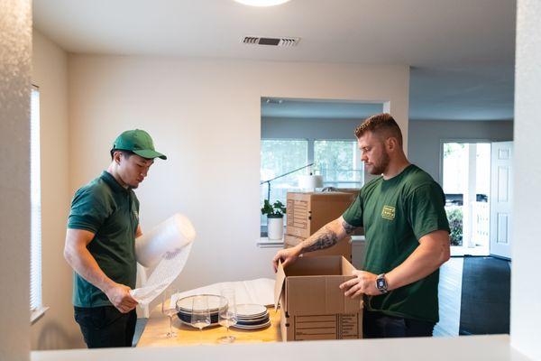 Professional packing service - dishes and fragile kitchenware securely wrapped for a damage-free move.
