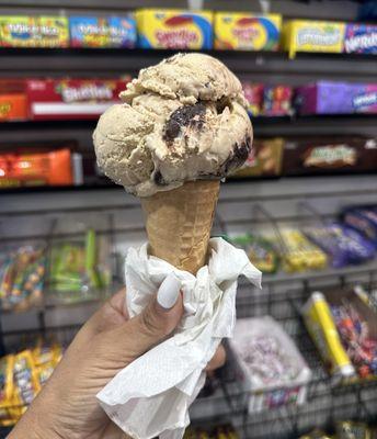 Coffee ice cream with chocolate chunks on a sugar cone