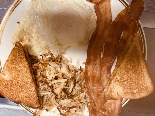 Two eggs, bacon, hashbrowns, and toast