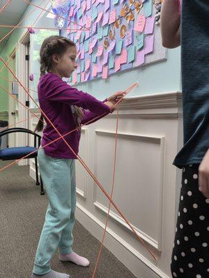Student constructing a "laser maze" down the hallway.