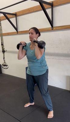 Woman pressing kettlebells