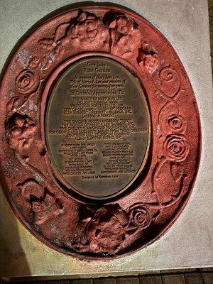 On the stairs outside the large tree