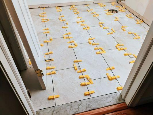 This is a picture of the NEW bathroom floor in progress of being installed.