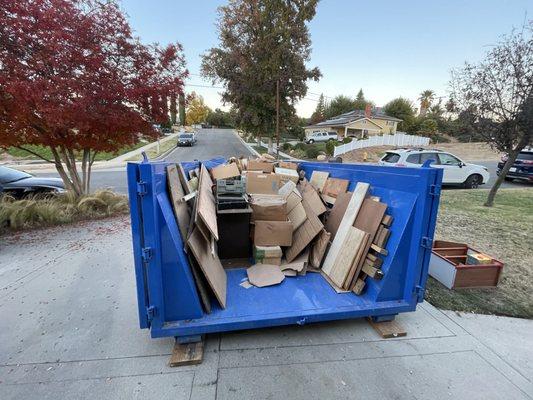 Dumpster perfect for easy residential cleanup- note wood blocks to protect driveway