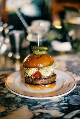 Burger Americaine | pastured wagyu beef, caramelized onion, cognac everything sauce, frisee, red pepper, toasted brioche - $27