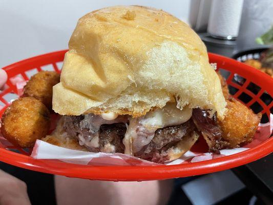 The Bacon Racelette Burger served w/4 hushpuppies. $17.00 (no side).  (2025)