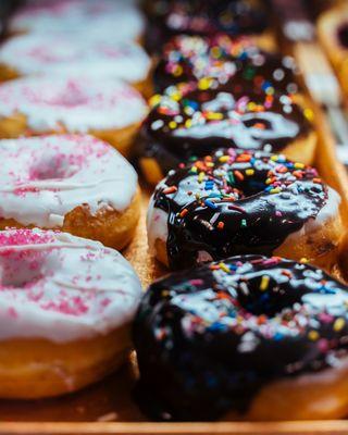 A variety of doughnuts in a display case.