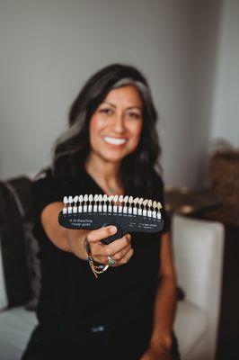 Ana, your trusted Holistic Teeth Whitening Practitioner holding up a tooth shade guide.