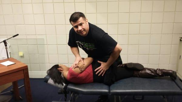Helping ease a patient's low back pain with a side-posture lumbar spine mobile chiropractic adjustment at her office.