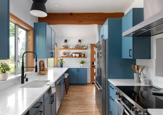 A new wrap-around layout and sleek blue cabinets transform this Mid-Century Modern galley kitchen in Seattle's Wedgwood neighborhood.