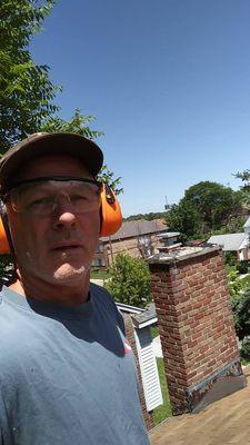Up on a roof! Clearing the overgrowth limbs.