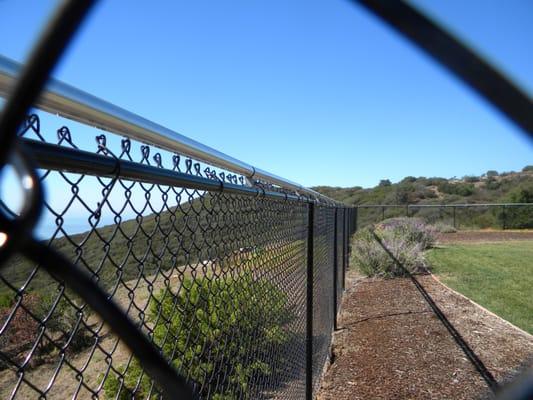 Black vinyl coated chain link with coyote rollers.
