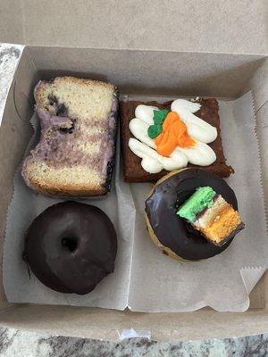 Blueberry cake slice, carrot cake slice, double chocolate donut, rainbow cookie donut. (Left to right, top to bottom)