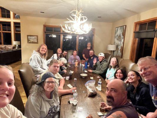 All 16 of us Playing cards at the large dinning table.