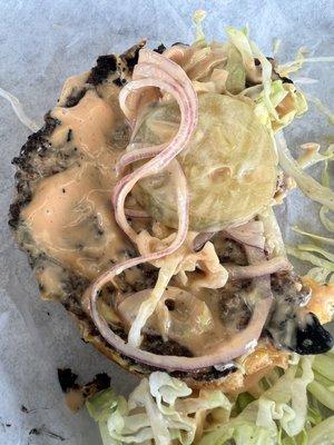 Thin, overcooked patty with burned edges.